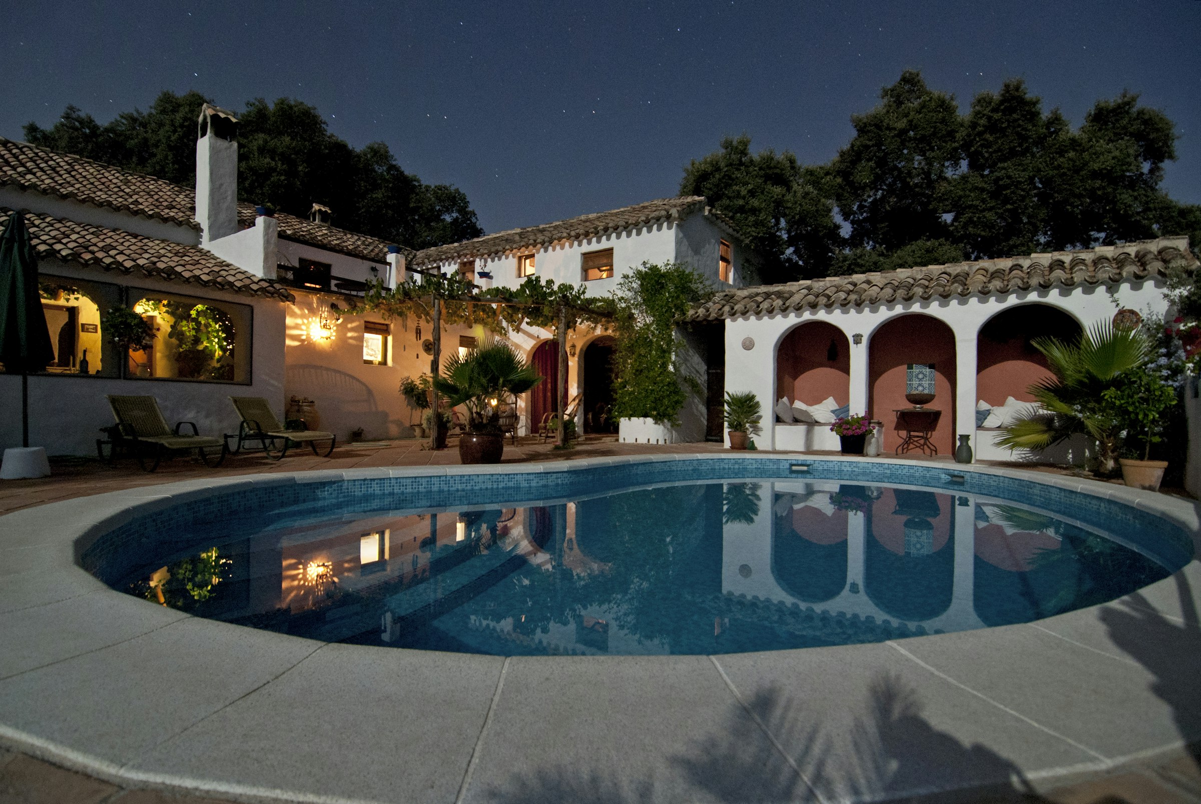 Lamplit resort courtyard pool at night