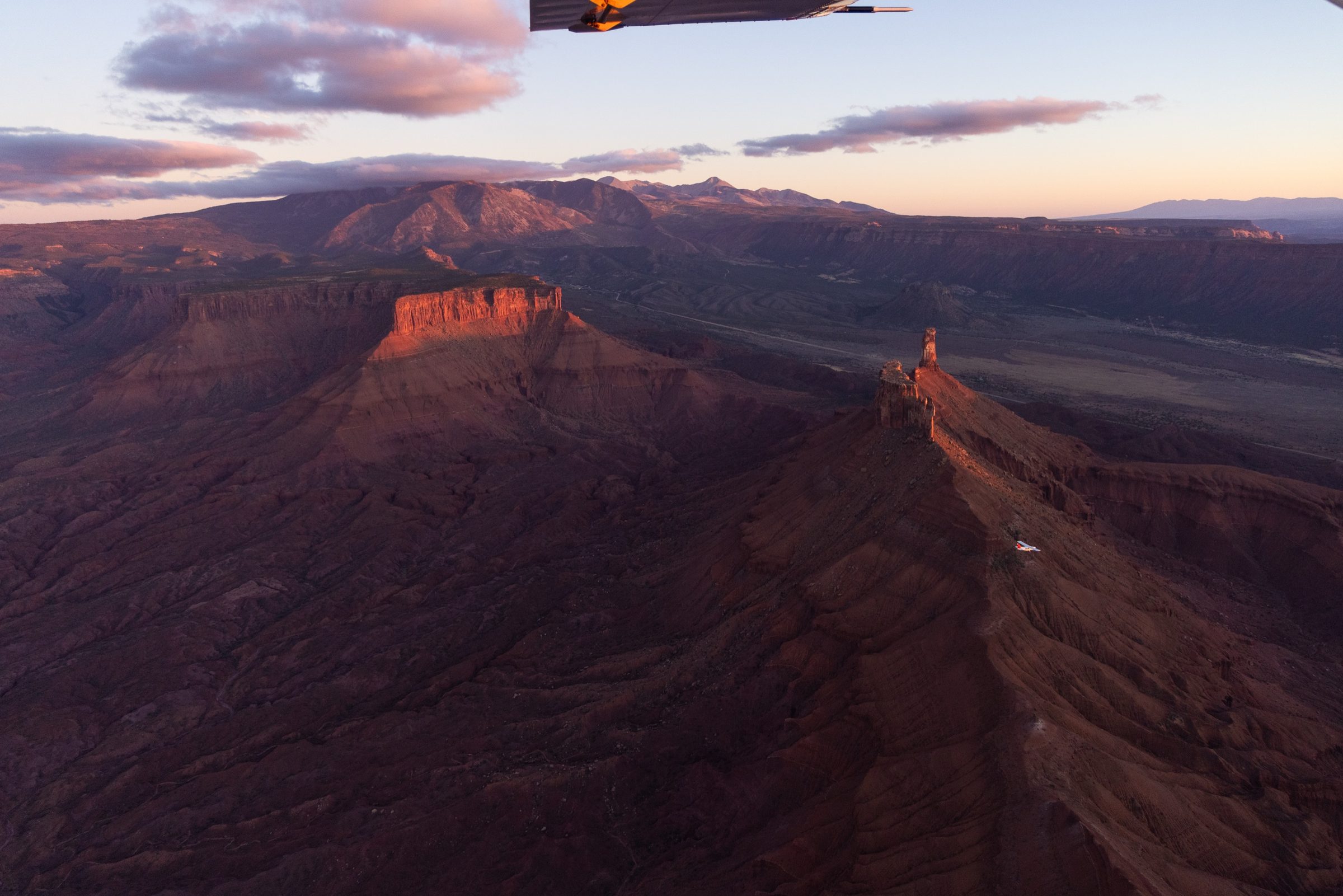 Canyon mesas catching the last red light at dusk, seen from the air