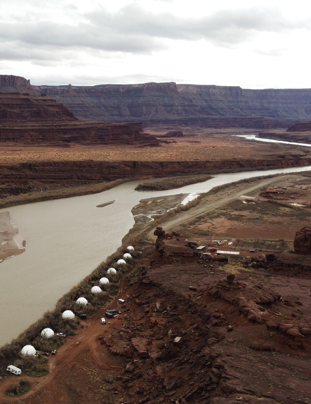 A row of guest domes along a river bend, seen from above