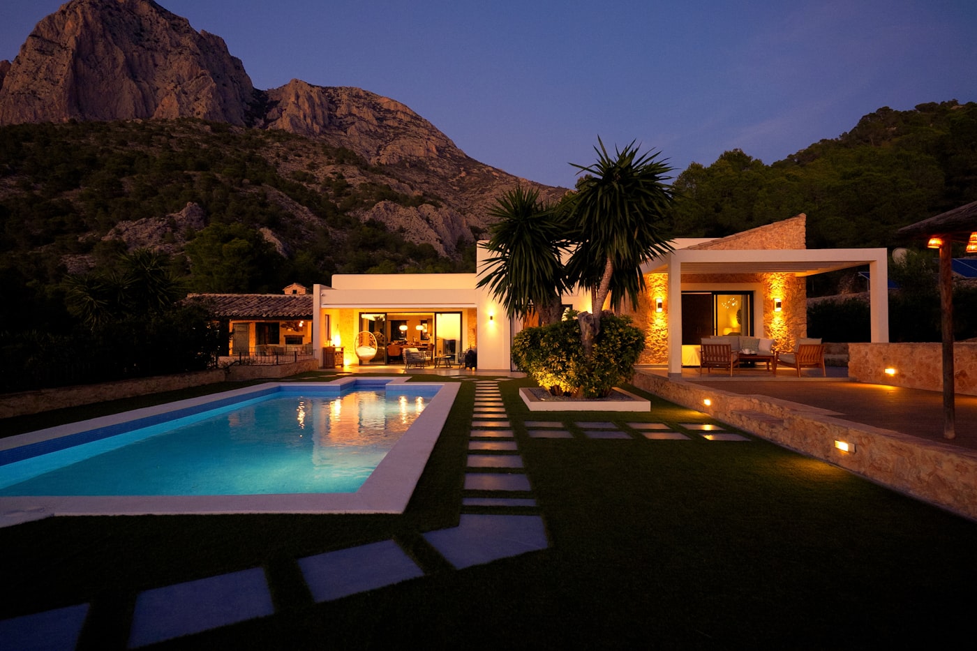 Desert villa and pool glowing warmly at night